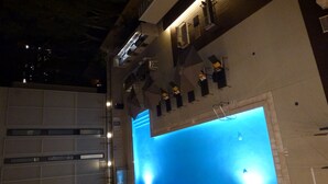 A modern building with a large illuminated blue pool. - New beautiful 2 Bedroom Unit in Biltmore District Walk to Shopping Restaurants (Phoenix)