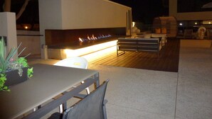 An outdoor patio area with a modern fire feature, seating, and a dining table. - New beautiful 2 Bedroom Unit in Biltmore District Walk to Shopping Restaurants (Phoenix)