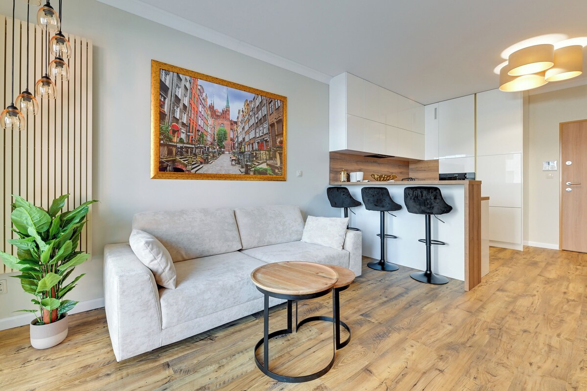 A modern living room with a sofa, a coffee table, and a potted plant.