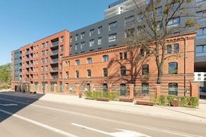 A multi-story building with a mix of brick and modern architecture, featuring balconies and large windows. - Bastion Wałowa City Center by Downtown Apartments (Gdansk)