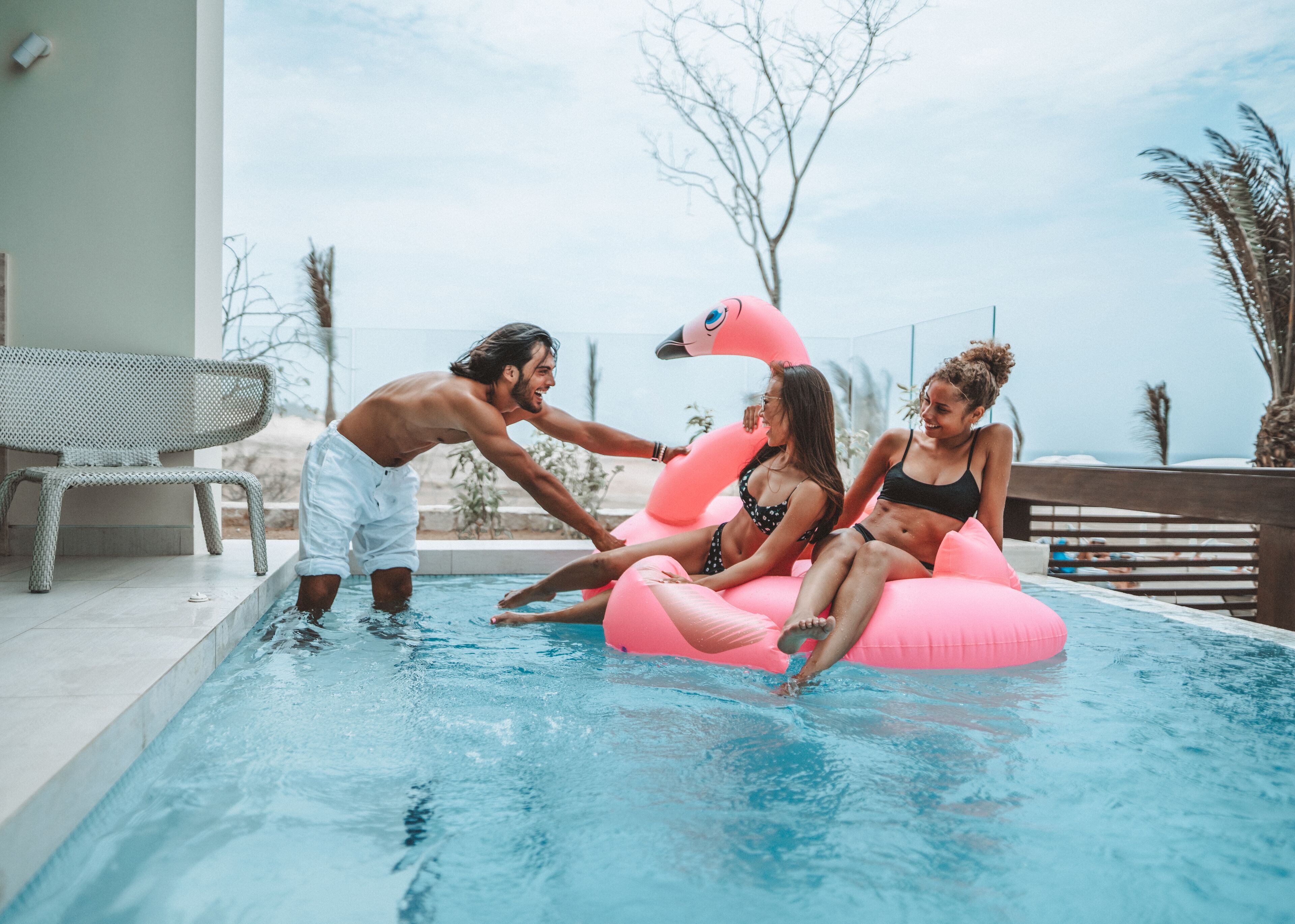 Zona de piscina con una silla de descanso y vista al océano.
