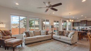 A spacious living room with a large sofa, a coffee table, and a fireplace. There is a kitchen area with a dining table and chairs. - Ladera Resort 370, Arcade Basketball, (2) X-Box Ones, and Community Pool (Washington)