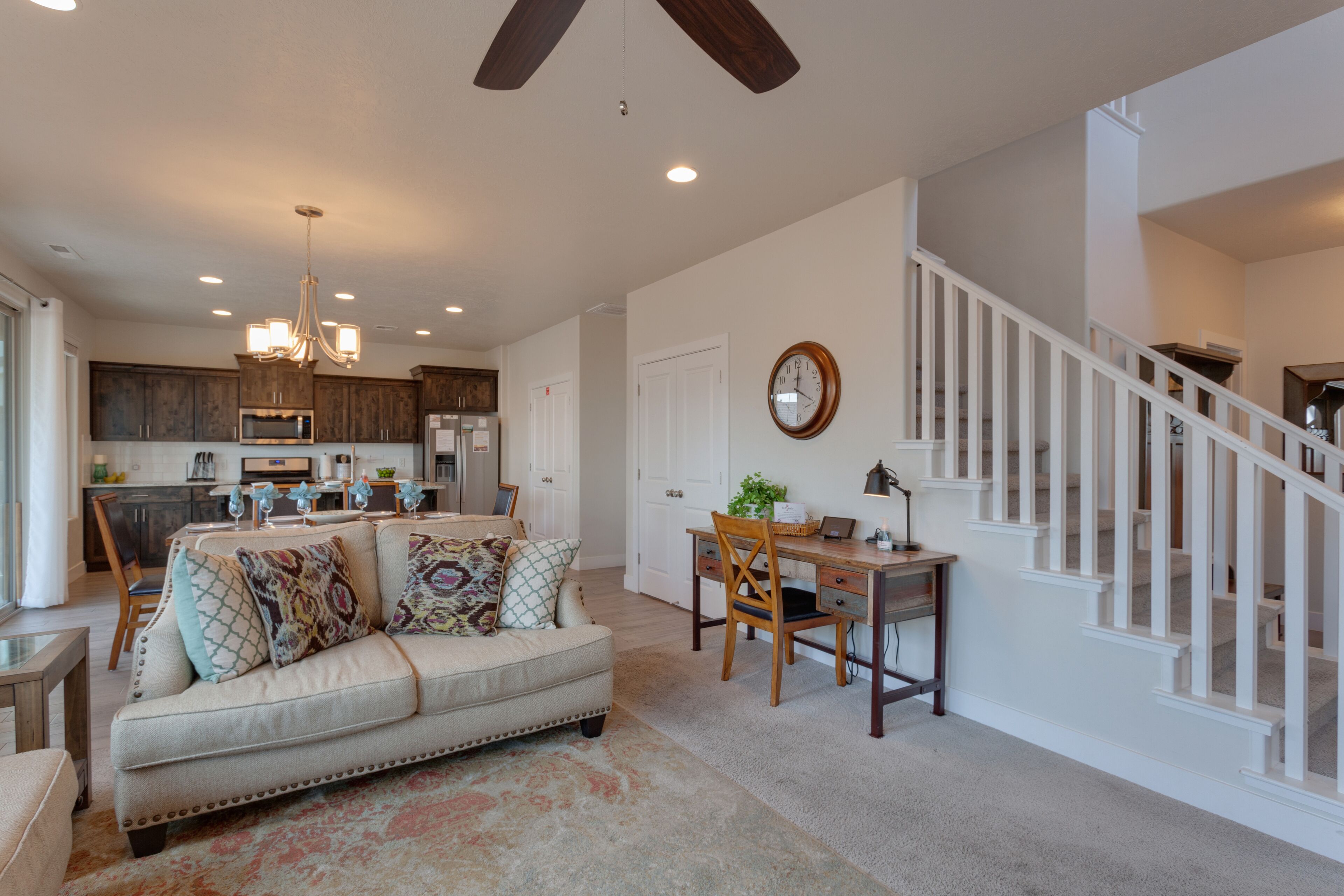 A spacious living room with a sofa, a dining table, and a staircase.