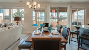 A dining area with a wooden table set for four, surrounded by chairs, and a sofa in the background. - Ladera Resort 370, Arcade Basketball, (2) X-Box Ones, and Community Pool (Washington)