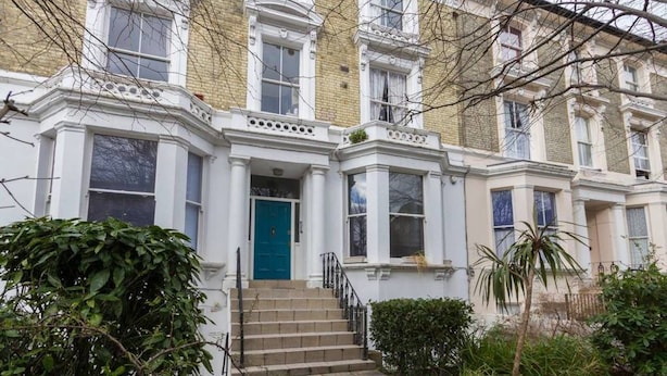 A Victorian-style townhouse with a blue door, white trim, and a set of stone steps leading to the entrance. - Cosy 1 Bedroom Flat in Notting Hill (London)