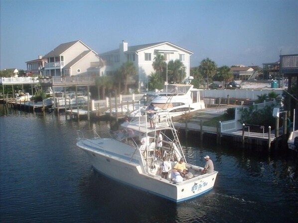 Guests can enjoy a boat with a cabin and seating area, docked at a marina with scenic views.