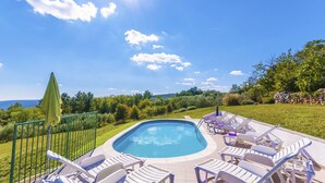 Une piscine avec des chaises longues et vue sur la mer.