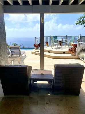Relax in this ocean-view seating area with two comfortable lounge chairs and a small table.