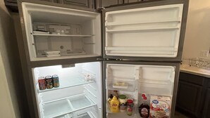 Et køkken med indbygget køleskab, træskabe og en bordplade.
