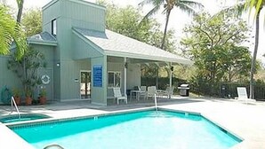 A swimming pool with a covered area and lounge chairs. - One Bedroom, First Floor, Fully Furnished Condo (Kailua-Kona)