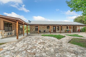 A stone building with a covered patio and outdoor seating area.