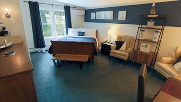 Hotelkamer met een bed, bureau, stoel, lamp, plank met decoratieve voorwerpen en raam met gordijnen.