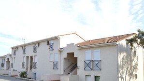 A row of two-story buildings with balconies, a central staircase, and a clear sky. - 2P/Mezzanine Apt 4 Pers in Saint-Aygulf - Terrace, Parking, Washing Machine (Saint-Aygulf)