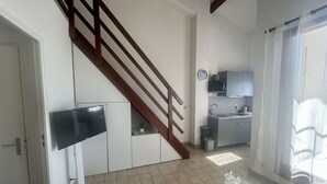 Un apartamento moderno con escalera, cocina y zona de estar.