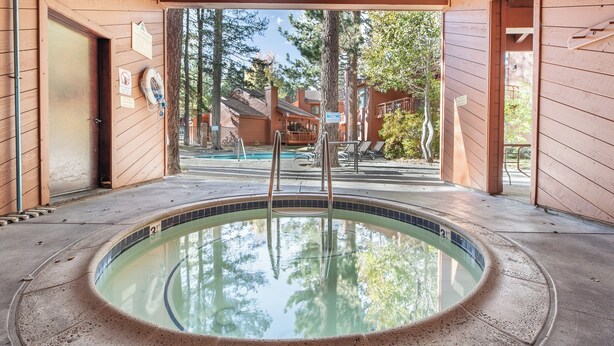 A wooden cabin with a pool, surrounded by trees and a clear sky. - Woodlands 2 Bedroom & Loft Townhouse In A Beautiful Wooded Complex (Mammoth Lakes)