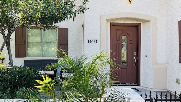 A building with a white exterior, a brown door, and a number '14074' on the wall.