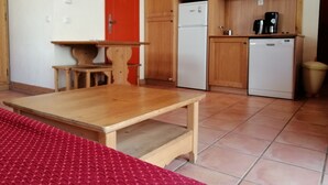 Una cucina compatta con mobili in legno, un forno a microonde, un frigorifero e una lavastoviglie.