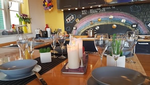 Ein Essbereich mit einer Tafel, auf der ein Regenbogen und der Text 'Welcome, Aussie 54 Perth 2013' stehen.