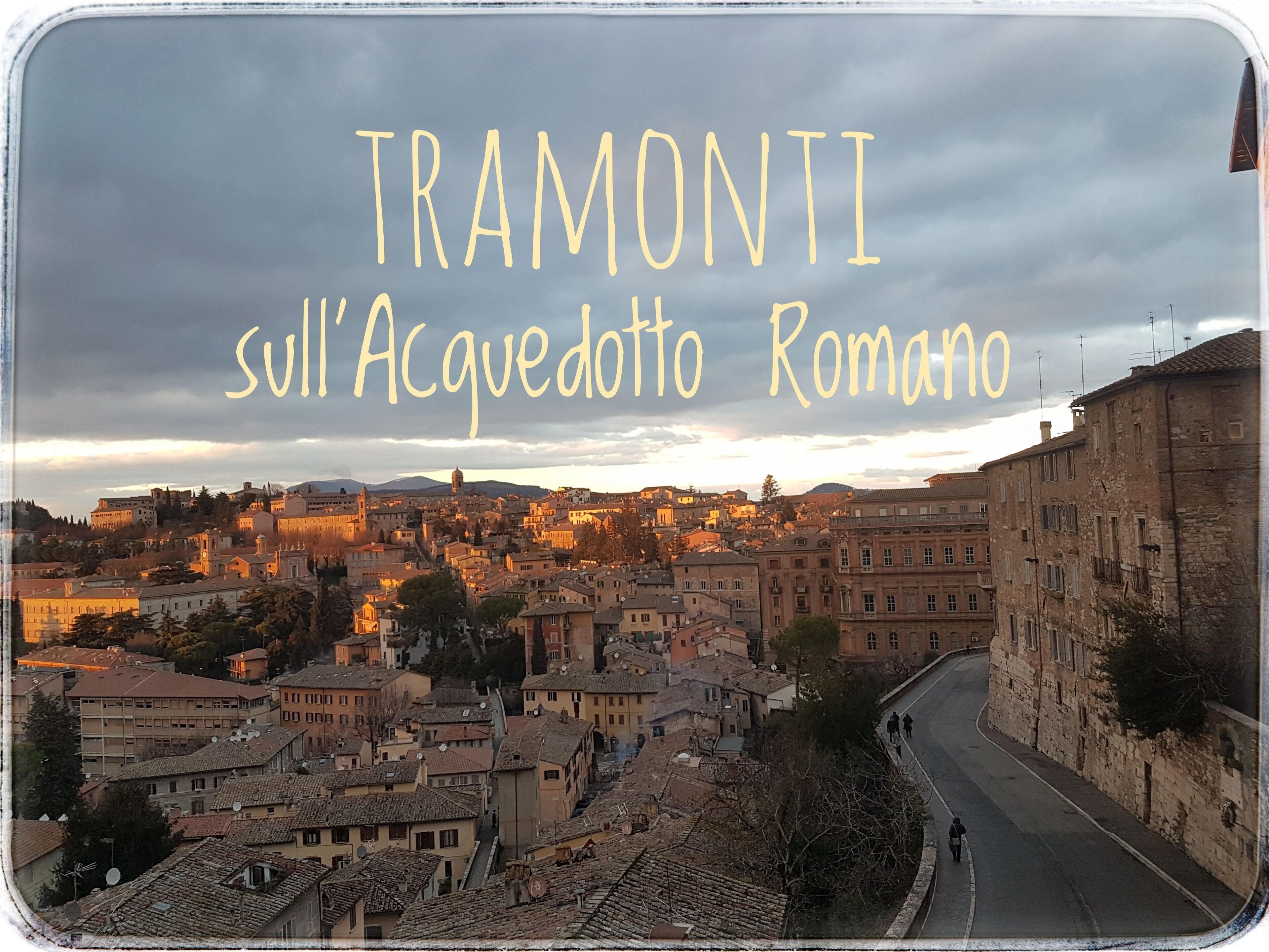 Vista panorâmica de Tramoniti, com edifícios históricos e uma estrada sinuosa.
