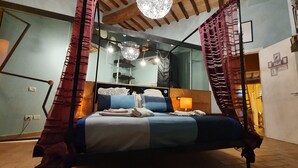 A bedroom with a bed, a mirror, and a chandelier. - Vacation House Maison Mavù Perugia Historical Center (Perugia)
