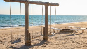Una playa con un columpio y mesas para pícnic.