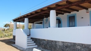 A building with a stone foundation, white walls, and a wooden roof structure. - The casuzza of RE !! (Malfa)