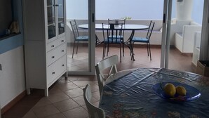 A balcony with a table and chairs, a cabinet, and a view of the sea. - The casuzza of RE !! (Malfa)