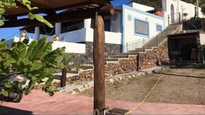 A modern building with a stone foundation and a blue and white facade. - The casuzza of RE !! (Malfa)