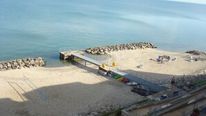 Ein Strand mit einer Seebrücke, klarem Wasser und einem Sandstrand.