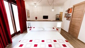 Una habitación de hotel con cama, escritorio y televisor.
