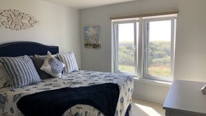 Ein Schlafzimmer mit Bett, Fenster und Schreibtisch.