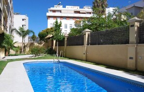 Relax by the rectangular pool surrounded by lush greenery and a concrete deck.