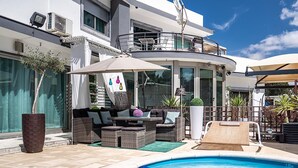 A modern outdoor pool area with wicker furniture, a lounge chair, and a small slide. - Cantua Villa, AC, Wifi, Swimming pool (Azeitão)