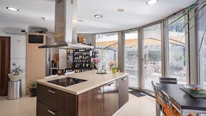 A modern kitchen with a central island, built-in appliances, and a large window offering a view of the city. - Cantua Villa, AC, Wifi, Swimming pool (Azeitão)