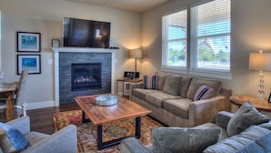 A living room with a fireplace, a television, and a sofa. - Sea Turtle Cottage - Oyhut Bay Seaside Village (Ocean Shores)