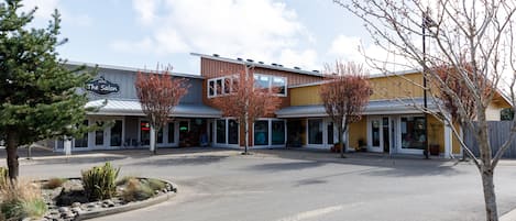 Ein Geschäftsgebäude mit Schaufenster, das den Namen "The Salon" trägt, und einem Parkplatz davor.