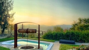 A stone well with a pulley system in a landscaped garden with a pool and a view of distant mountains. - Self catering Residence Masnaiot for 2 people (Cossano Belbo)