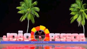 A stage with palm trees and a colorful sign that reads "JOÃO PESSOA". - Pousada Refúgio (João Pessoa)