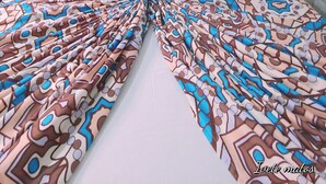 A hotel room with a bed featuring a patterned bedspread, two decorative pillows, and a wall with blue mosaic tiles. - Pousada Refúgio (João Pessoa)