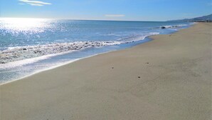 Une plage avec un ciel dégagé et une mer calme.