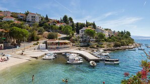 A coastal town with a marina, clear blue waters, and buildings with red-tiled roofs. - LUKAS 1, charming 2-bedroom apartment (Okrug Gornji)