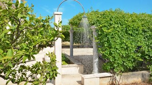 A fountain with water jets in a garden area with steps and greenery. - LUKAS 1, charming 2-bedroom apartment (Okrug Gornji)