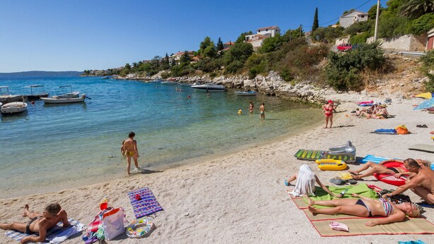 A beach with clear water, boats, and people sunbathing. - LUKAS 1, charming 2-bedroom apartment (Okrug Gornji)