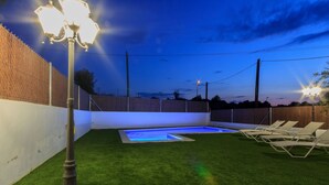 A backyard with artificial grass, a swimming pool, and lounge chairs. - Villa Can Roig by Hello Homes Sitges (Sitges)