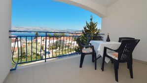 A balcony with a table and chairs, overlooking a scenic view of a lake and mountains. - BLUEHOUSE 2, cozy apartment for 4 persons, 250m from a pebble beach (Okrug Gornji)