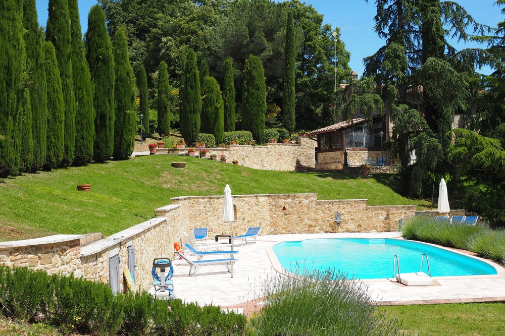Casa Acacia, an ancient tower surrounded by the green hills of San Giminiano