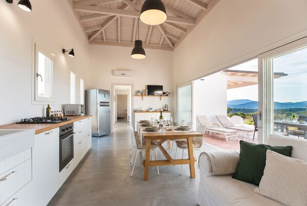 Una cocina moderna con comedor, ventanas amplias y vistas al exterior.