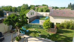 Un pati amb piscina, una zona tancada i un petit jardí.