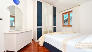 Ein Schlafzimmer mit einem Bett, einem Schminktisch, einem Kleiderschrank und einem Fenster.