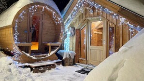 Een houten hut met een buitenkant bedekt met sneeuw en een rond raam.